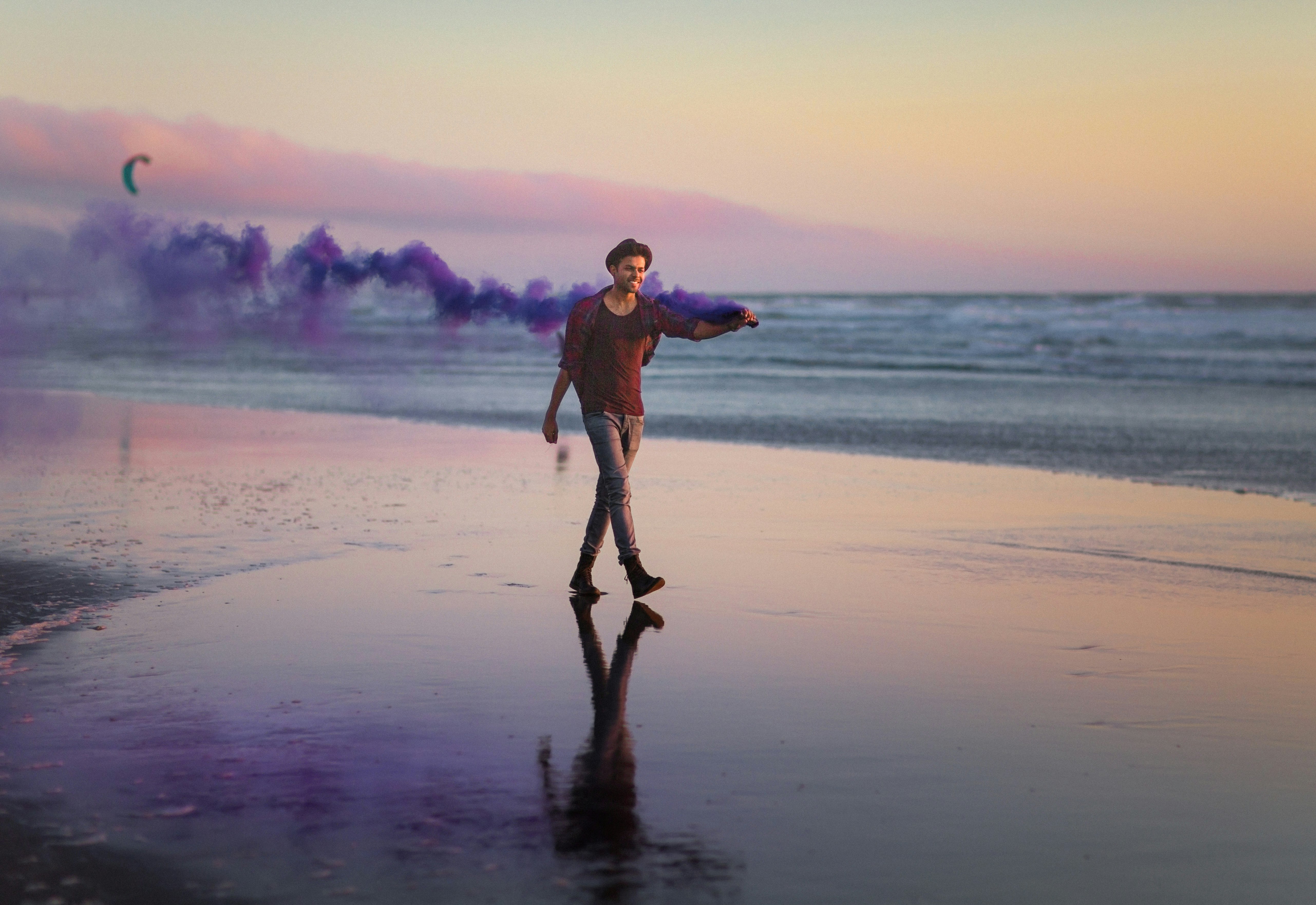 man in red shirt walking on the shore